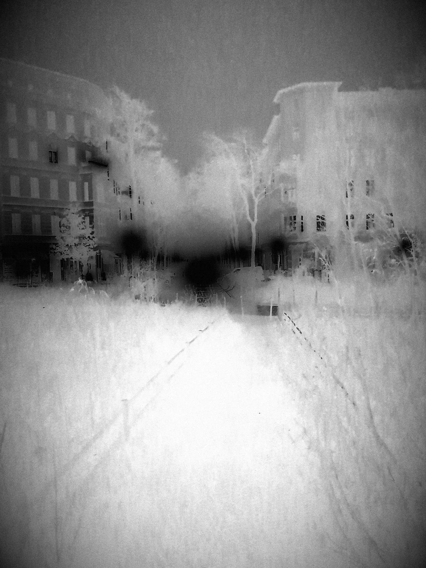 Une rue vide, la nuit. Photographie noir et blanc. Négative.