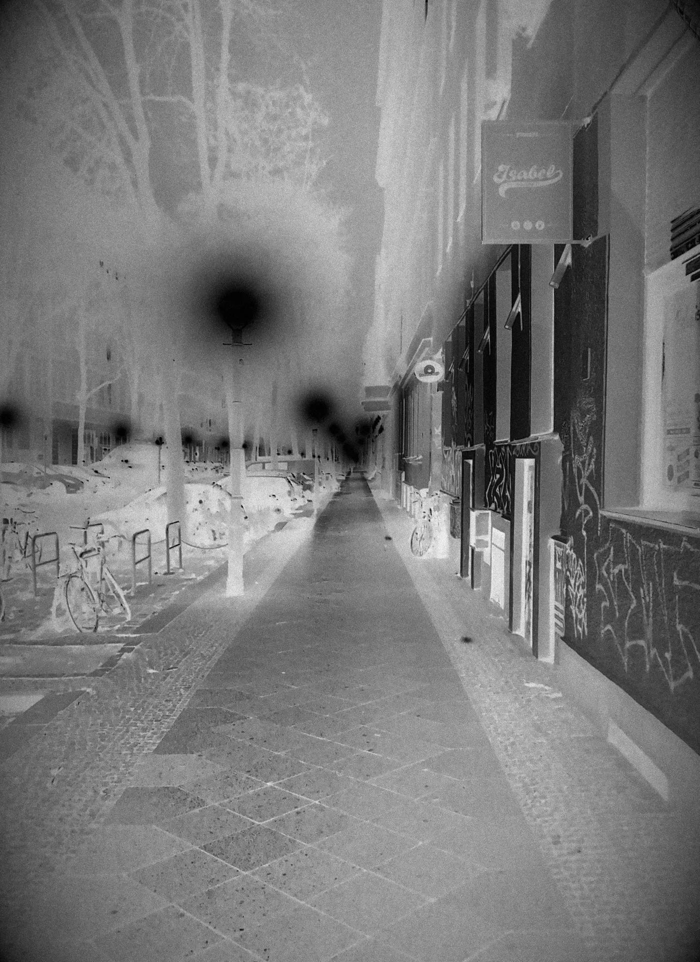 Une rue vide, la nuit. Photographie noir et blanc. Négative.